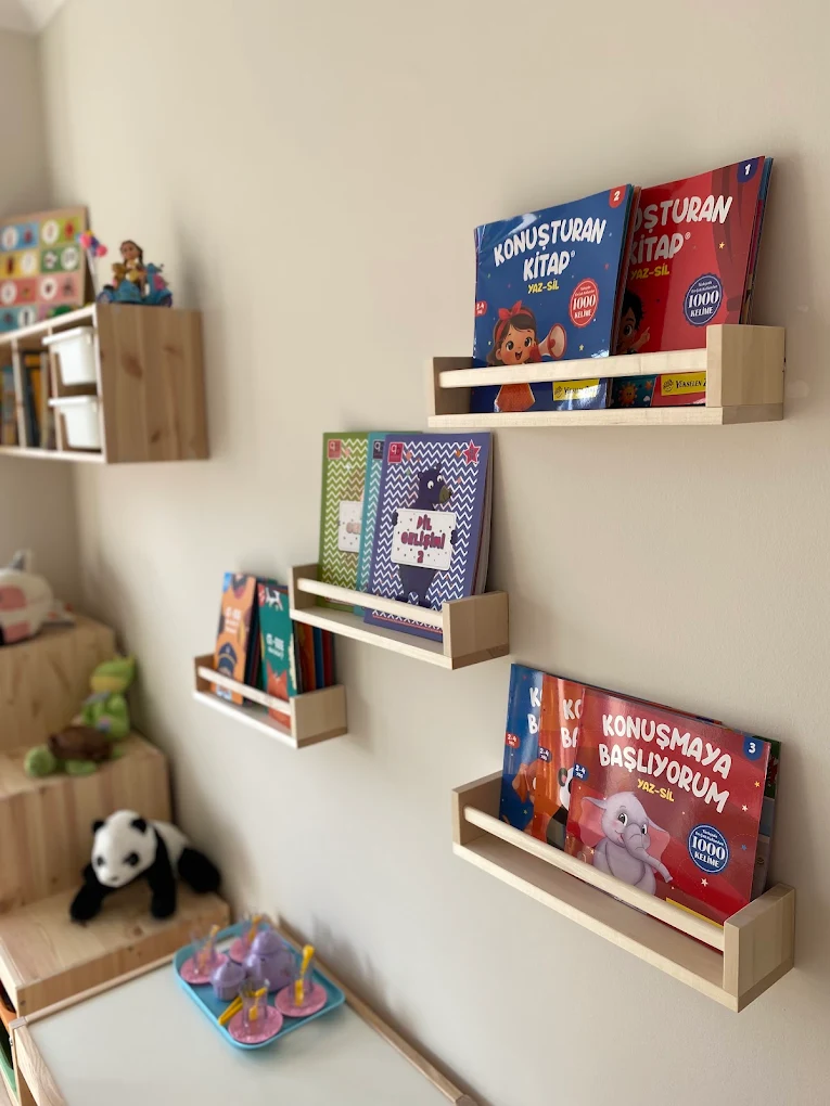Ahşap duvar raflarında çocuk kitapları ve oyuncaklar